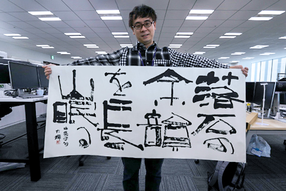 書道の作品を持つ男性