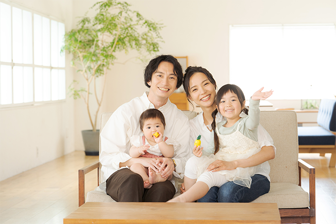 ソファに座る4人家族の画像