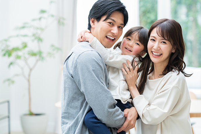 子どもを抱く夫婦の画像