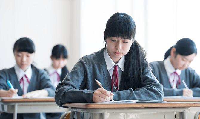 学校で勉学に励む女子高生の様子